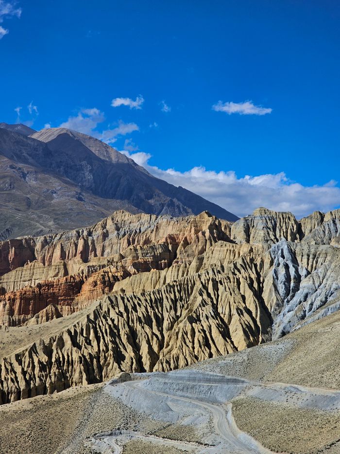 Dramatic rock formations under a vibrant blue sky in Mustang, Nepal.